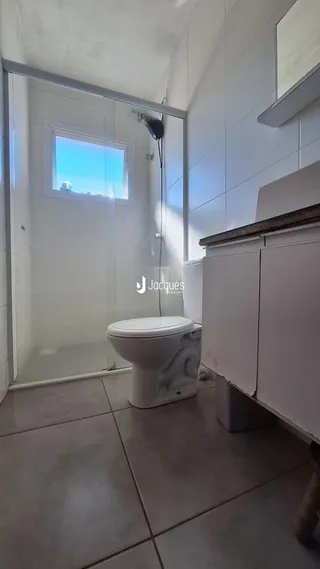 Foto de um banheiro interno com piso de cerâmica e janela.