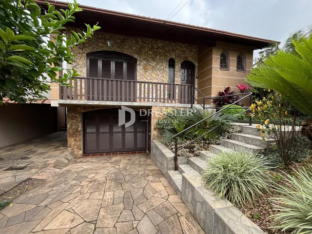 Fachada de uma residência em Lajeado, Brasil, com área externa pavimentada e jardim.