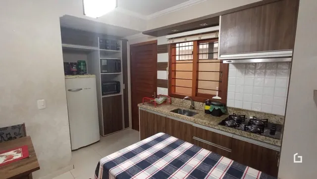 Interior da cozinha com armários de madeira e bancada.