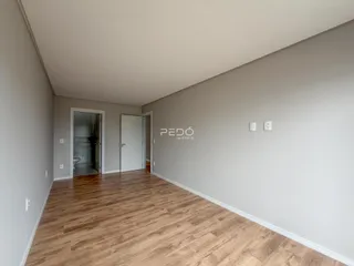 Corredor interno com piso de madeira clara.