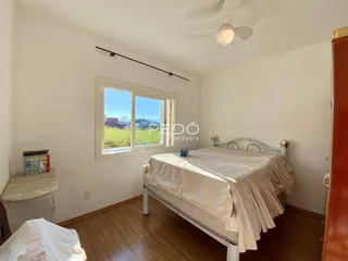 Quarto com janela e cama de madeira no interior da residência.