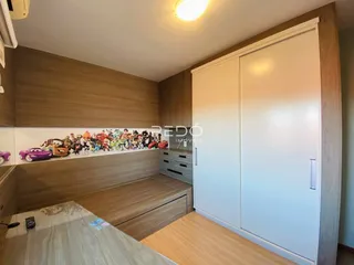 Ambiente interno com painéis de madeira e armários brancos em um imóvel.