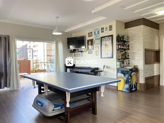 Sala de estar com mesa grande e área de entretenimento.