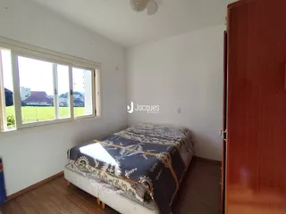 Quarto com janela e piso de madeira.