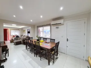 Sala de estar com piso de cerâmica e mesa de madeira.
