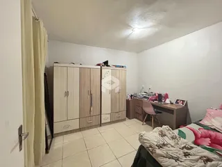 Quarto com armários embutidos e piso de cerâmica claro.