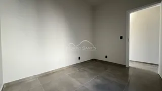Foto de um ambiente interno com paredes brancas e piso de cerâmica.