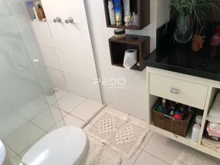 Foto de um banheiro com piso de cerâmica e bancada branca.