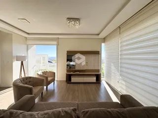 Sala de estar com piso de madeira e grandes janelas.