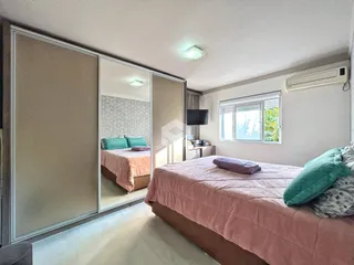 Quarto com cama e armário espelhado em um imóvel no Brasil.
