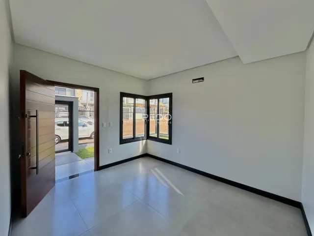 Interior de uma sala de estar com piso de cerâmica e porta de vidro.