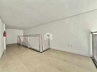 Vista de um corredor interno com piso de cerâmica e grade de metal.