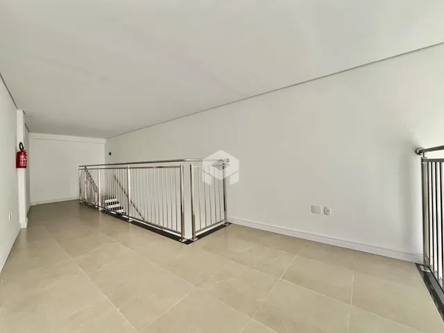 Vista de um corredor interno com piso de cerâmica e grade de metal.