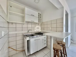 Foto de uma cozinha com revestimento de cerâmica branca e armários brancos.
