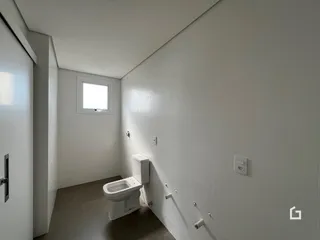 A foto mostra um banheiro com piso de cerâmica e paredes brancas.