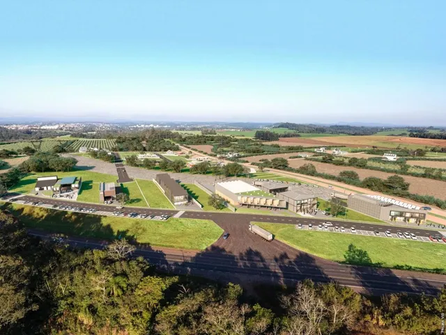 Vista aérea de uma propriedade rural com campos e vegetação no horizonte.