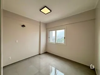 Foto de um ambiente interno com paredes brancas e piso de cerâmica.