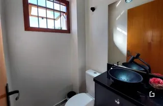 Foto de um banheiro com janela e armário.