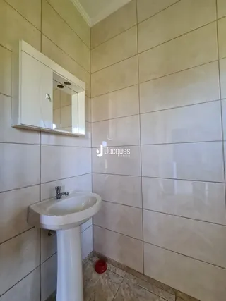 Parede com revestimento cerâmico e pia de apoio em um ambiente residencial.