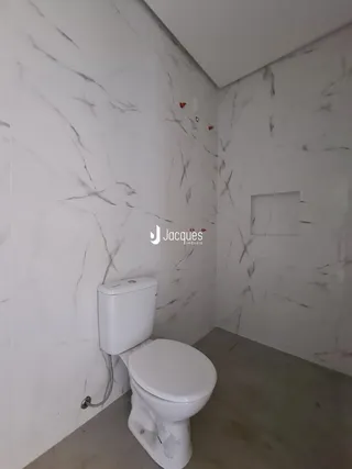 Foto de um banheiro com paredes em efeito mármore branco.