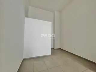 Interior de um ambiente com paredes brancas e piso de cerâmica.