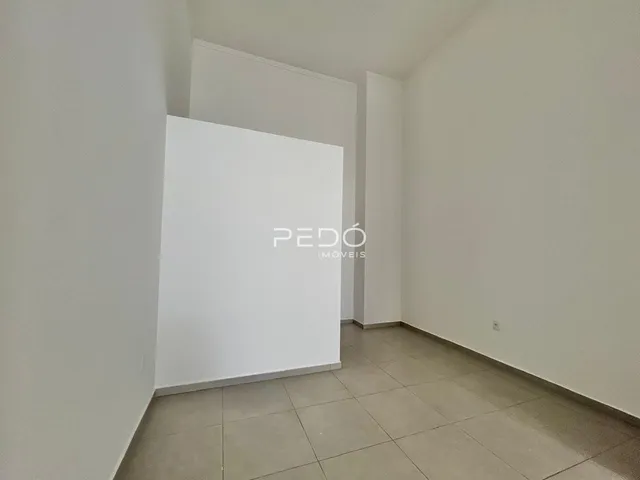 Interior de um ambiente com paredes brancas e piso de cerâmica.