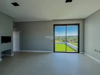 Sala de estar com porta de vidro abrindo para um jardim verde.