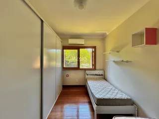 Quarto com armário e cama de madeira no interior da residência.