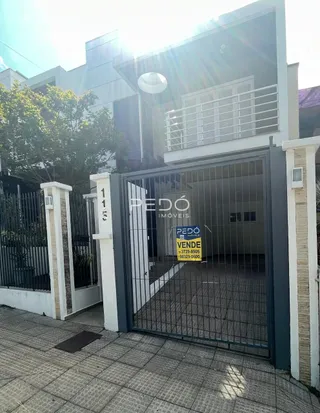 Fachada de uma residência com portão de metal na entrada.