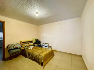 Quarto com cama e móveis de madeira em um imóvel no Brasil.