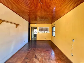 Corredor com piso de ladrilho e teto de madeira em ambiente residencial.
