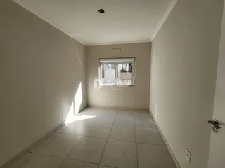 Corredor interno com piso de cerâmica e janela.
