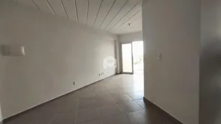 Vista interna de um corredor com piso de cerâmica clara e paredes brancas.