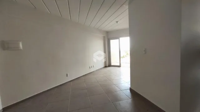 Vista interna de um corredor com piso de cerâmica clara e paredes brancas.