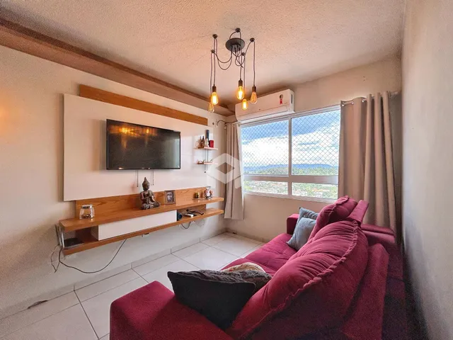 Sala de estar com sofá vermelho e janela com vista para a paisagem.