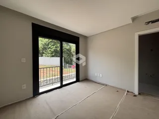 Vista interna de um cômodo com porta de vidro e vista para o exterior.