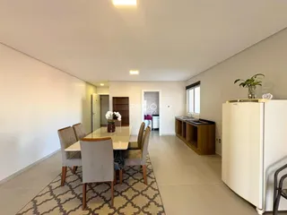 Sala de jantar clara com mesa de madeira em um imóvel no Brasil.