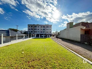 Vista de um gramado verde em frente a um edifício residencial.