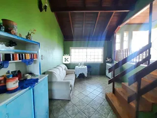 Sala de estar com sofá branco e piso de cerâmica.
