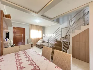 Quarto com cama grande e cortinas claras em ambiente interno.
