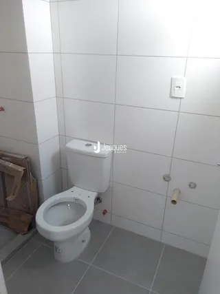 Foto de um banheiro com revestimento cerâmico branco.