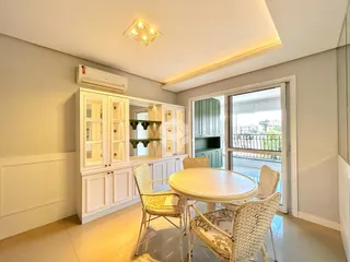 Ambiente interno de uma sala com mesa de jantar e armários embutidos.