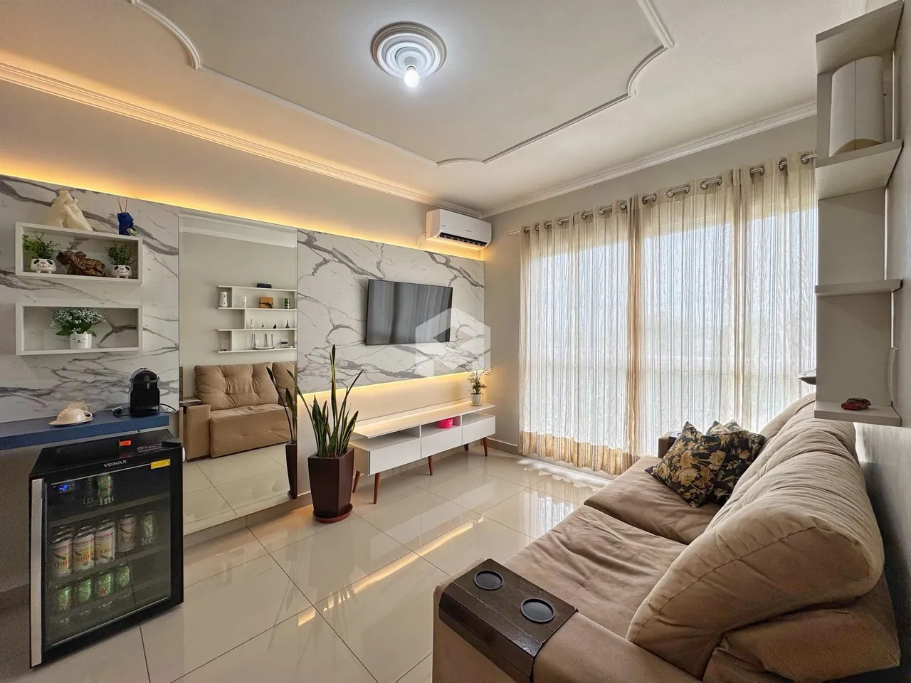 Sala de estar moderna com paredes de mármore e iluminação embutida.