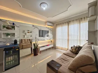 Sala de estar moderna com paredes de mármore e iluminação embutida.