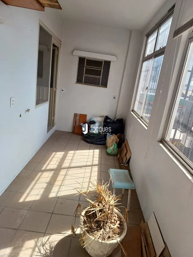 Vista de um corredor interno com piso de cerâmica e luz natural.