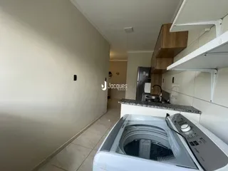Vista interna de uma cozinha com armários brancos e piso de cerâmica.