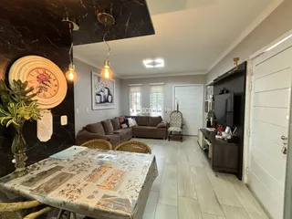 Sala de estar com parede de mármore escura e piso claro.