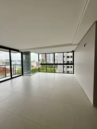 Espaço amplo com grandes janelas de vidro em uma residência.
