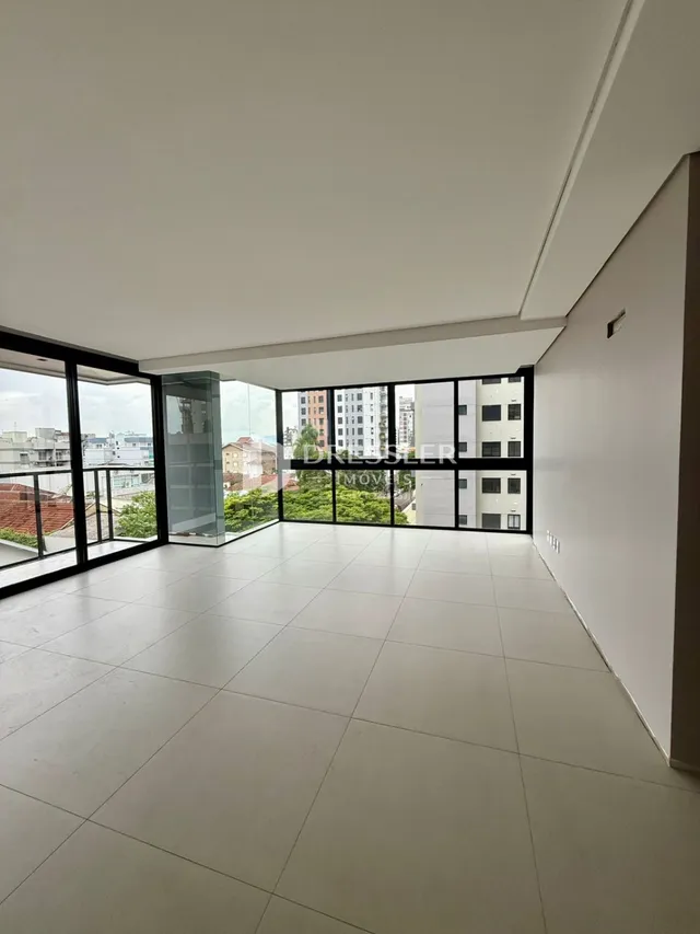 Espaço amplo com grandes janelas de vidro em uma residência.