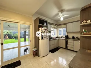 Cozinha com armários brancos e piso de cerâmica em um imóvel em Lajeado.